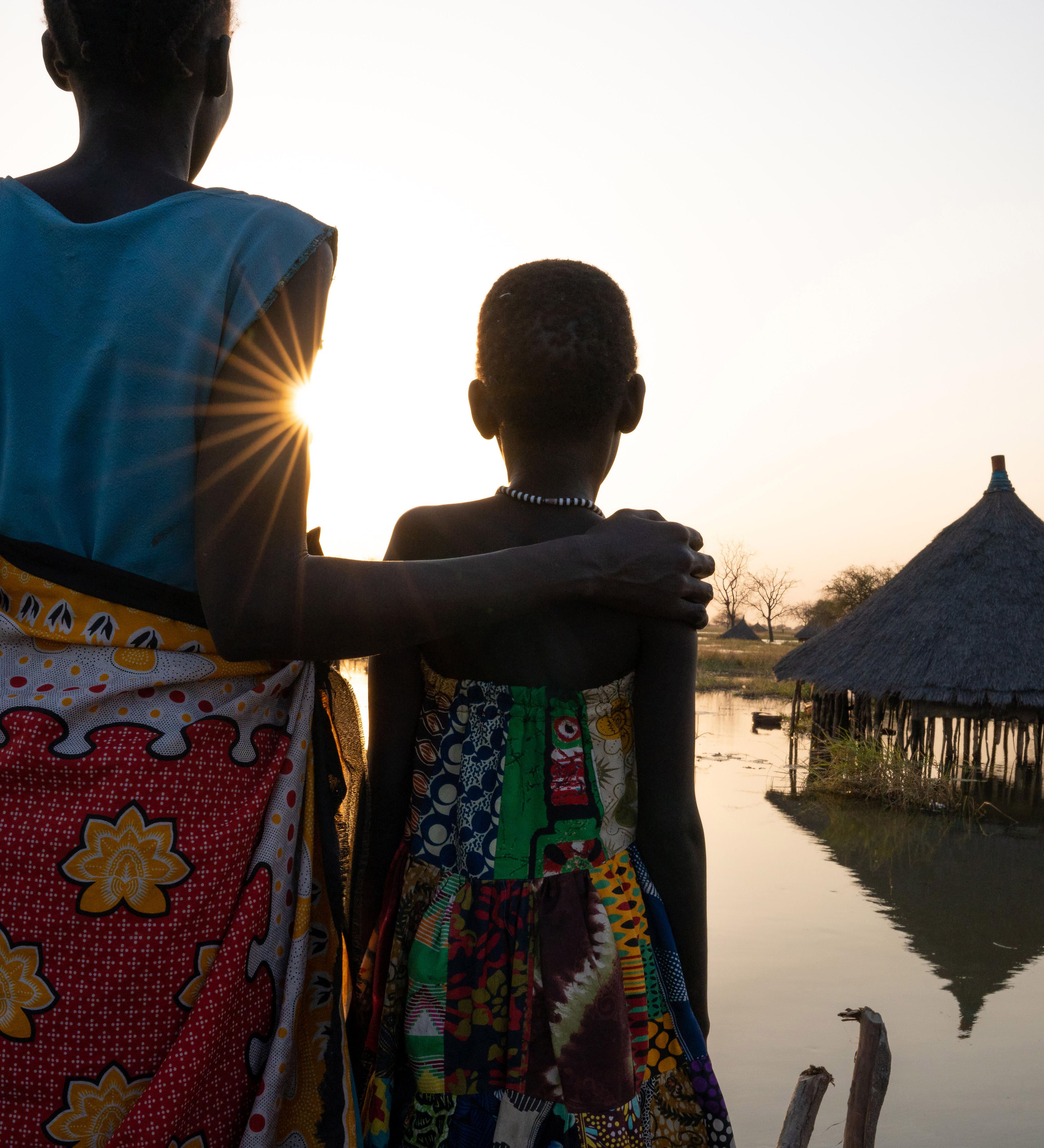 © UNICEF/UN0594299/Naftalin A mother and daughter look out over submerged houses in Panyagor in Twic East, Jonglei State in South Sudan.